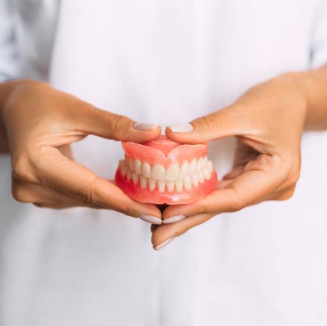 Lady presents viewer with dentures