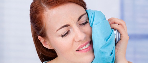 Woman icing her cheek