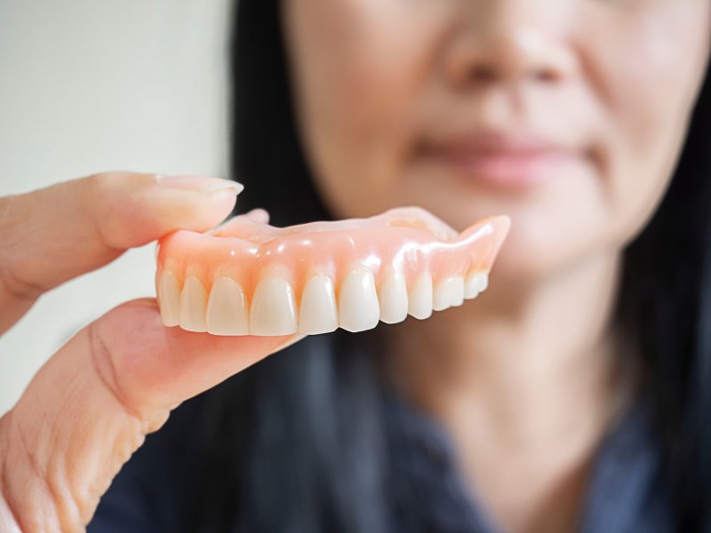 a person holding a set of dentures